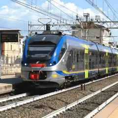 Nowoczesny pociąg wjeżdża na stację, przypominając miejski transport, jak neapol metro.