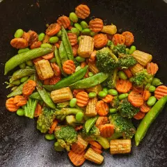 Kolorowa mieszanka chińska z brokułami, marchewką, edamame i kukurydzą, gotowa do podania jako kurczak po chińsku.
