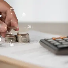 Dłoń układa monety, obok kalkulator i dokumenty. Ikony symbolizują finanse i prawo, sugerując rozważania nad umową zlecenie a KRUS.