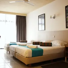 Pokój w hotelu Canifor Malta z dwoma łóżkami, zasłonami i widokiem na zewnątrz.