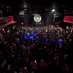 Folla in delirio al Nitsa Club, luci soffuse e musica pulsante.