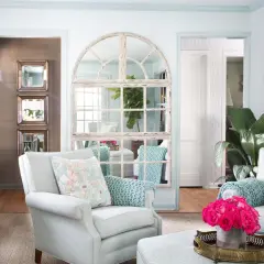 Charming mirror wall ideas: a large arched window mirror and stacked square mirrors create depth and light in this elegant living room.