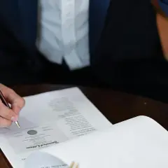 Persona firma un contrato laboral con un bolígrafo de oro.