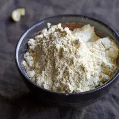 Schüssel mit hellem Proteinpulver. Man kann Proteinpulver erhitzen, um es in Backwaren zu verwenden.