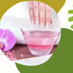Zabieg parafinowy na dłonie. Czy parafina ciekła jest szkodliwa? Delikatne dłonie zanurzone w różowej kąpieli, obok kwiat orchidei.