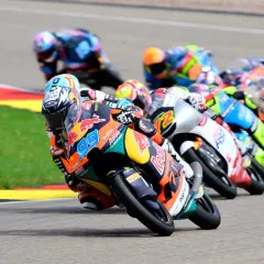 Pilotos de Moto3 compiten en una carrera, mostrando la potencia y velocidad de estas motos. El número 99 destaca en primer plano.