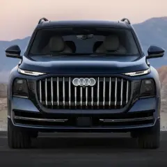 L'imponente Audi Q9 si staglia su uno sfondo desertico, con la sua griglia audace e i fari affilati che catturano lo sguardo.