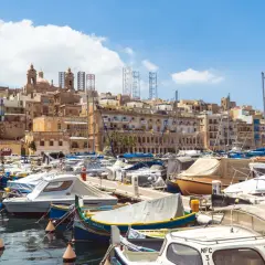 Port w Valletcie, gdzie cumują łodzie. Widok na zabytkowe budynki i wieże. Waluta na Malcie to euro, ale tu liczy się widok!