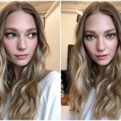 En kvinna med blont, vågigt hår och en subtil, naturlig makeup som framhäver hennes blå ögon och rosiga kinder.