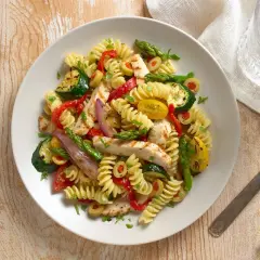Sabrosa ensalada de pasta con pollo a la parrilla, calabacín, pimientos rojos, espárragos y aceitunas.