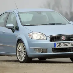 Jasnoniebieski Fiat Linea z polskimi tablicami SB 0671A jedzie po drodze.