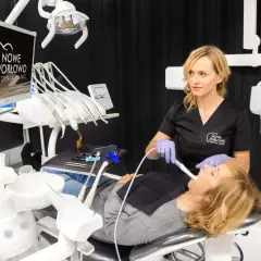Dentystka bada zęby pacjentki, wyjaśniając, czy próchnica jest zaraźliwa.