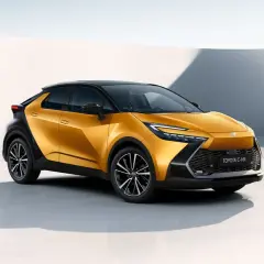 Nowa Toyota C-HR w kolorze złoto-czarnym, stylowa toyota hybryda, prezentuje się dynamicznie na tle minimalistycznej architektury.