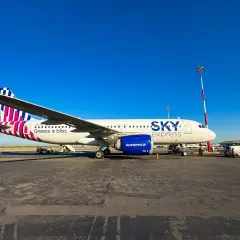 Samolot greckich linii lotniczych Sky Express na płycie lotniska. Napis "Greece is bliss" zapowiada podróż.