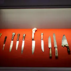 Ausstellung im Klingenmuseum Solingen: Eine Reihe historischer Messer mit kunstvollen Griffen auf rotem Samt.