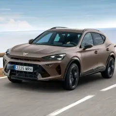 Brązowy Cupra Formentor na krętej drodze nad morzem. Sprawdź cupra formentor dane techniczne.
