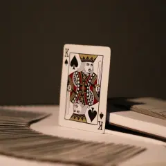 Król pik znaczenie. Pojedyncza karta, król pik, stoi na stosie kart.
