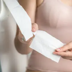 Kobieta zrywa papier toaletowy, zastanawiając się, czy piwo jest moczopędne.