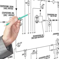 Main d'un homme en costume pointant un schéma technique complexe avec un crayon. Le schéma représente un système de tuyauterie et de vannes, avec des symboles et du texte. Le va et vient des fluides est représenté par des flèches.