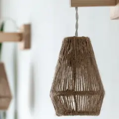 Dos lámparas de pared colgantes de cuerda natural, con soportes de madera, crean un ambiente rústico y acogedor.