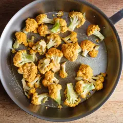 Orangefarbener Blumenkohl wird in einer Pfanne gebraten, um ihn zu kochen.