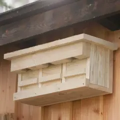 Ein selbstgebauter Nistkasten aus hellem Holz, bereit für gefiederte Gäste.