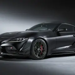 Mroczna Toyota GR Supra z matowym czarnym lakierem i agresywnym spojlerem, gotowa do podboju toru.