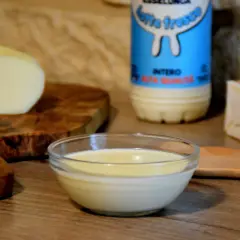 Una ciotola di cremosa fonduta di scamorza affumicata, con latte fresco e burro, pronta per essere gustata.