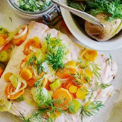 En vacker portion inkokt lax med morötter, purjolök och dill. Serveras med kokt potatis och en krämig sås.