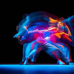 Tancerze w ruchu, tworzący świetlne smugi. Zastanawiasz się, ile zarabia choreograf tańca?