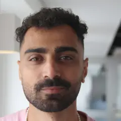 Alexander Abdallah, en ung man med lockigt mörkt hår och skägg, tittar rakt in i kameran.