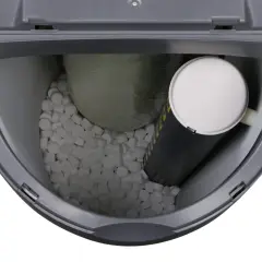 Wnętrze zmiękczacza wody z solą tabletkowaną, cylindrycznym wkładem i dużą, owiniętą żywicą. Poziom wody w zmiękczaczu jest niski.