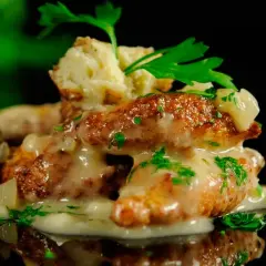 Deliciosas albóndigas de rape doradas, cubiertas con una cremosa salsa y perejil fresco. Un plato que invita a probar.
