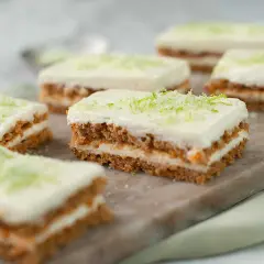 Små bitar av saftig morotskaka med krämig frosting och rivet limeskal. Perfekt för ett enkelt morotskaka recept.