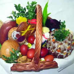 Koszyk wielkanocny z tradycyjnym święceniem pokarmów: chleb, kiełbasa, jajka, babka, zieleń i ozdoby.