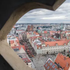 Widok z wieży widokowej we Wrocławiu na Rynek i Ostrów Tumski. Widać kolorowe kamienice, targ i katedrę.
