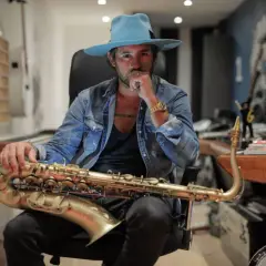 Uomo con cappello azzurro e sax dorato, un'icona del jazz.