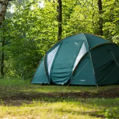 Zielony namiot rozbity w lesie, idealne miejsce, gdzie pod namiot nad jezioro.