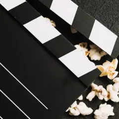 Klapka filmowa i popcorn – idealne połączenie do oglądania polskich filmów kinowych.