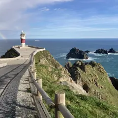 Faro en Cabo Ortegal con arcoíris. Un paisaje espectacular que ver, con el mar azul y rocas escarpadas.