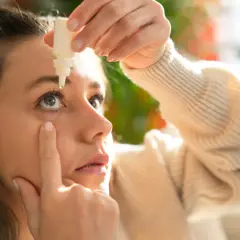 Donna applica collirio per alleviare i sintomi della congiuntivite allergica, cercando sollievo rapido.