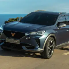 Niebieski SUV Cupra Formentor jedzie nad morzem. To jeden z wielu modeli, które można znaleźć, przeglądając marki samochodów alfabetycznie.