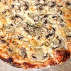 Pyszna pizza capricciosa z pieczarkami i ciągnącym się serem, idealna na wieczór z przyjaciółmi.