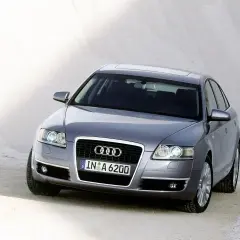 Szary Audi C6 z tablicą rejestracyjną IN A 6200 stoi na piaszczystym podłożu.