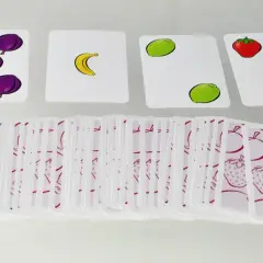Karty do gry halli galli z owocami: śliwki, banan, limonki, truskawki. Stos kart z owocowym wzorem.