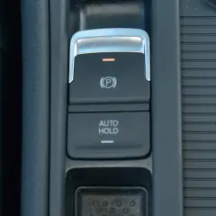 Przycisk AUTO HOLD w samochodzie. To funkcja, która automatycznie utrzymuje pojazd w miejscu po zatrzymaniu.