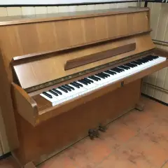 Drewniane pianino pionowe z klawiaturą. Zastanawiasz się, ile waży pianino? To instrument, który wymaga siły do przeniesienia.