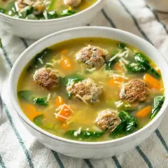 Pyszna zupa klopsowa babci z klopsikami, makaronem nitki, marchewką i szpinakiem w aromatycznym bulionie.