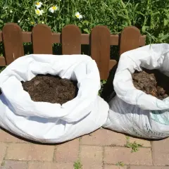 Dwa worki z ziemią czekają na sadzenie ziemniaków.