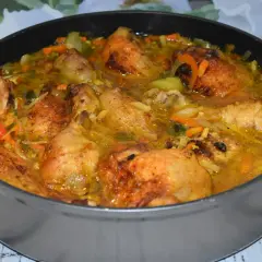 Pyszne udko po chińsku w sosie z warzywami, podane w głębokiej patelni.